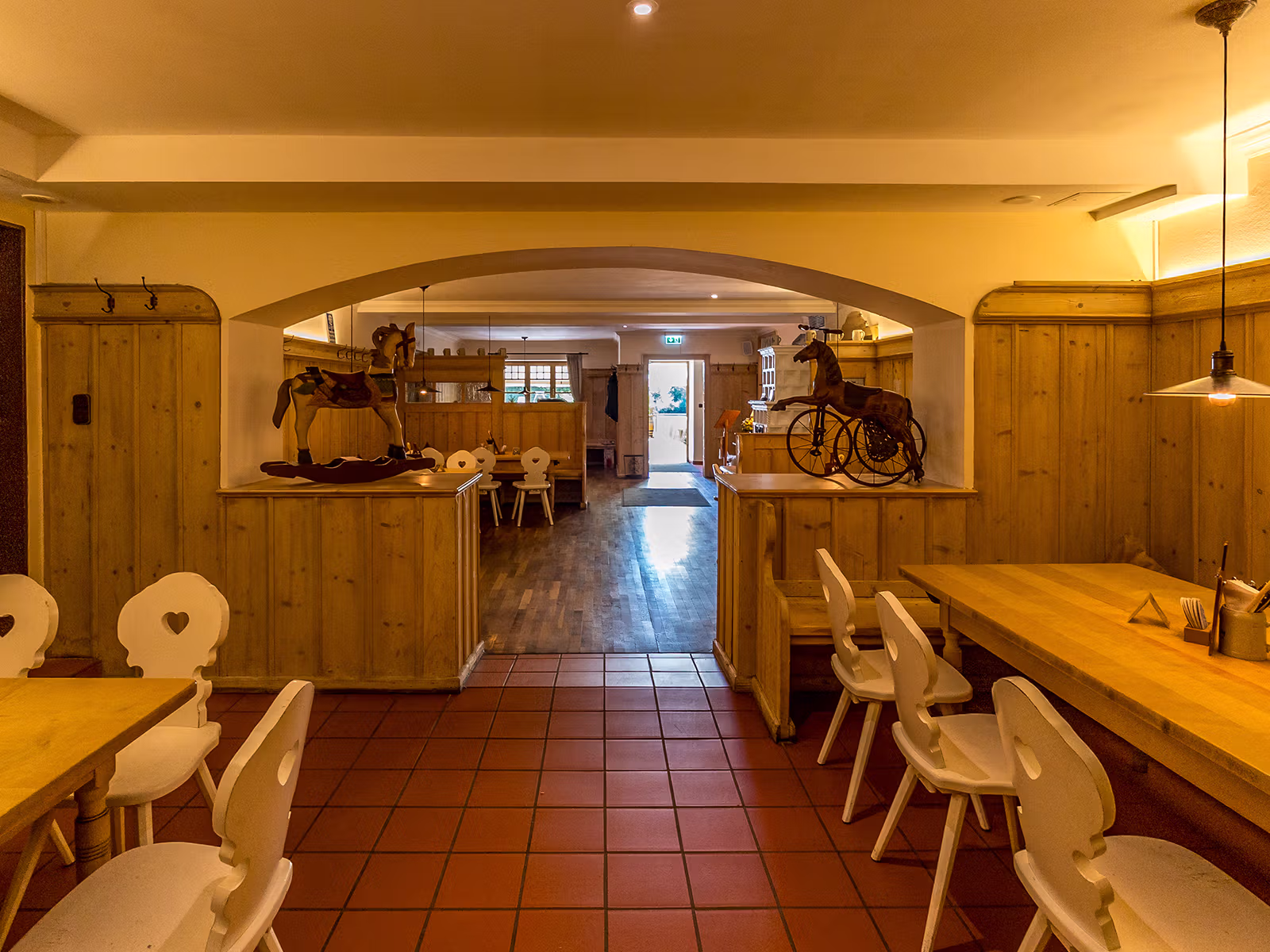 Bräustüberl mit heller Holzvertäfelung und dekorativen Schaukelpferden im Gasthof Hinterbrühl